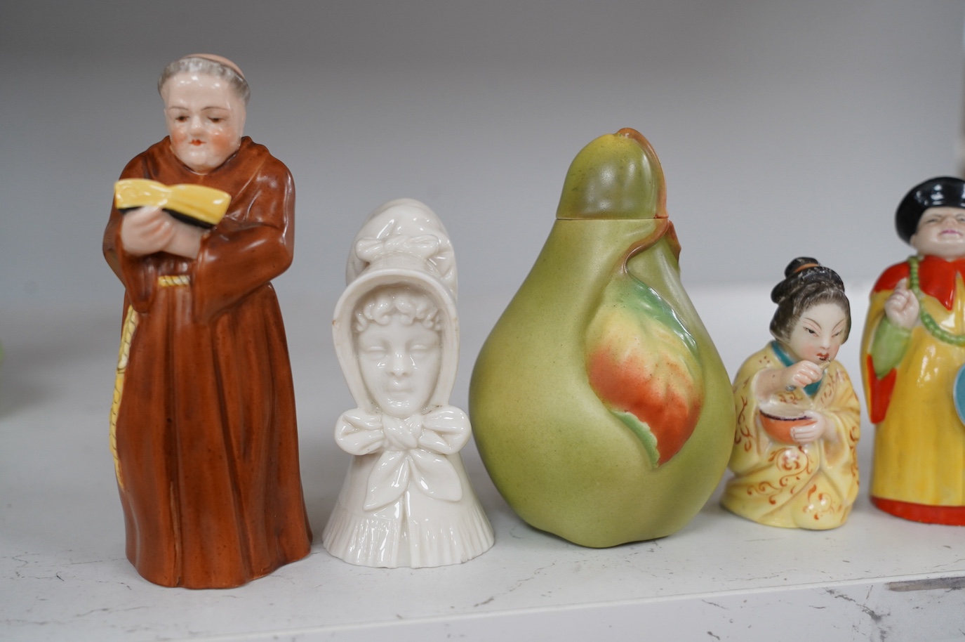 A group of six Royal Worcester figural candle extinguishers and an unusual 1906 pear box and cover, tallest 12cm (7). Condition - good